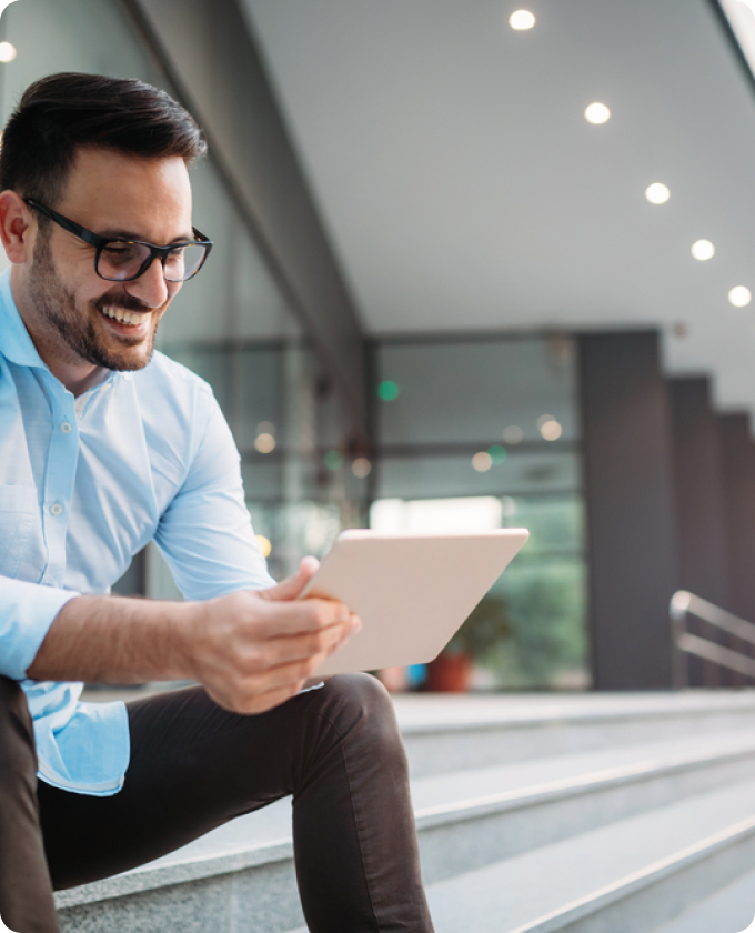 this image shows a man smiling broadly as he checks his electronic tablet, presumably answering questions with ease as his service provider is using Gatheroo to keep his information secure.