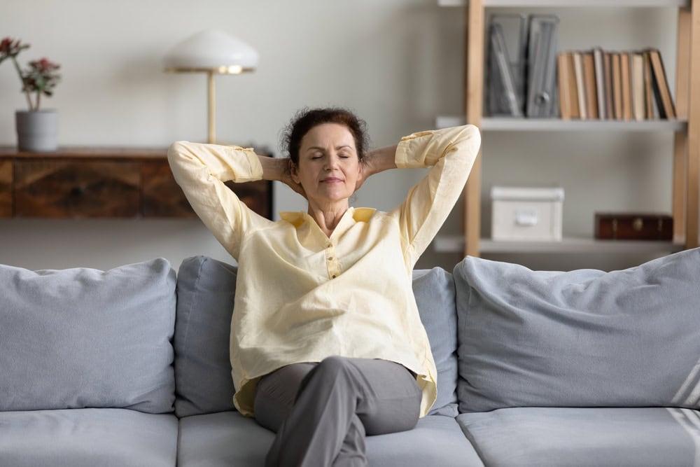 This photo shows Anne able to relax on a sofa, safe in the knowledge she is using a secure client portal to collect information from her clients