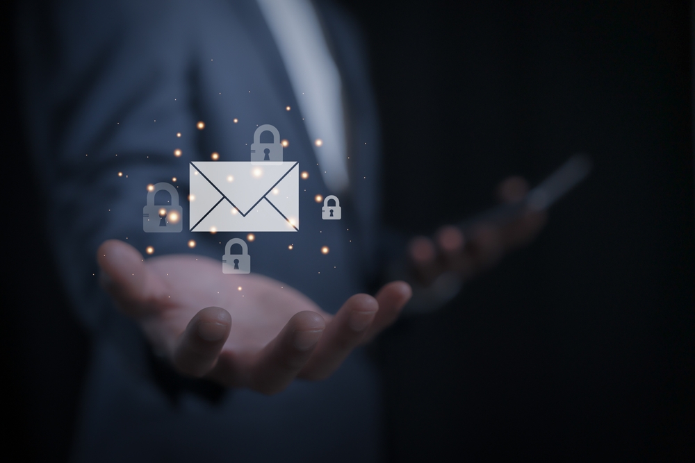 A man's arm is outstretched and and email is hovering above his hand. There are closed padlocks circulating the email, depicting the security of an encrypted email.