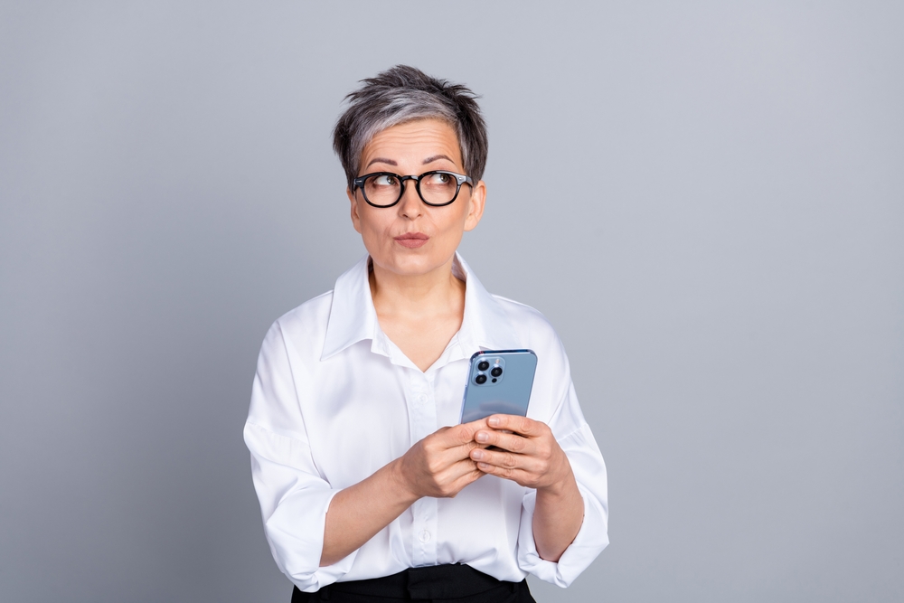 Jane, a bookkeeper, is holder her phone and looking worried. This is how she looked before she started using Gatheroo, as clients often texted her copies of legal documents.