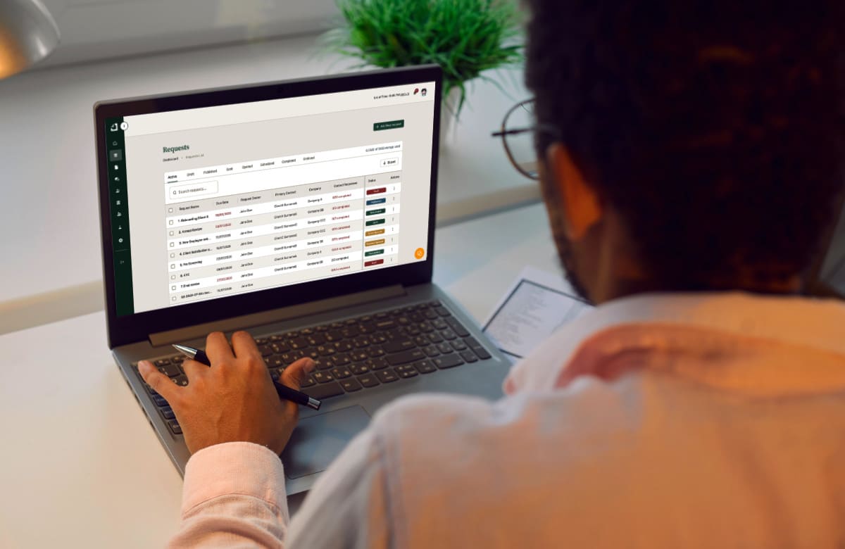 Businessman or financial accountant working with business spreadsheets on laptop computer. African American man sitting at office desk and looking at screen of notebook PC, back view, over shoulder